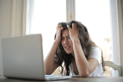 Woman wearing a white shirt showing frustration 