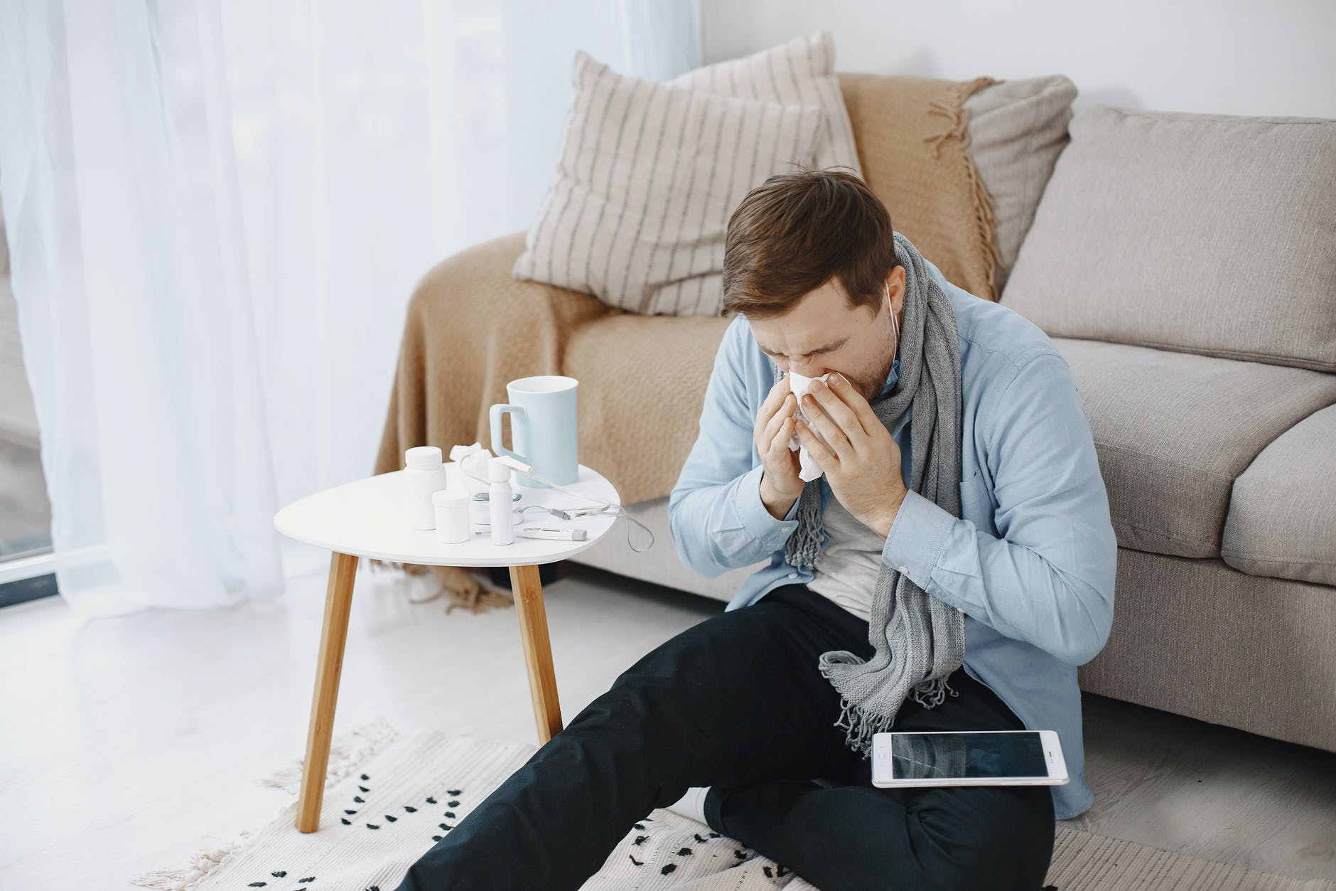 a man having flu sitting with his iPad