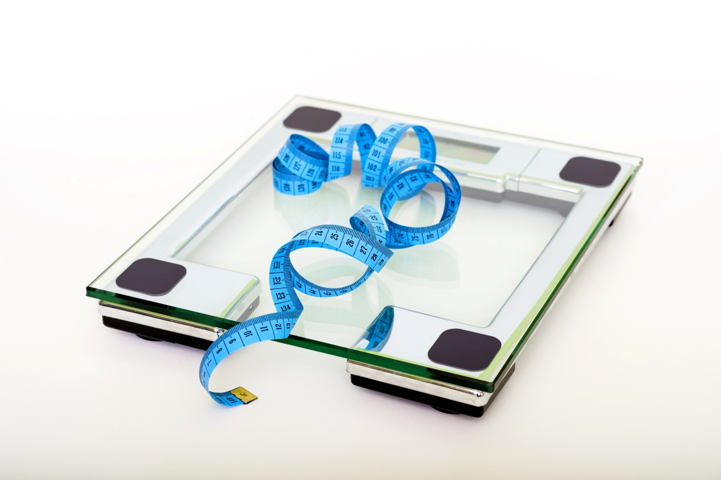 A measuring tape on a glass bathroom scale