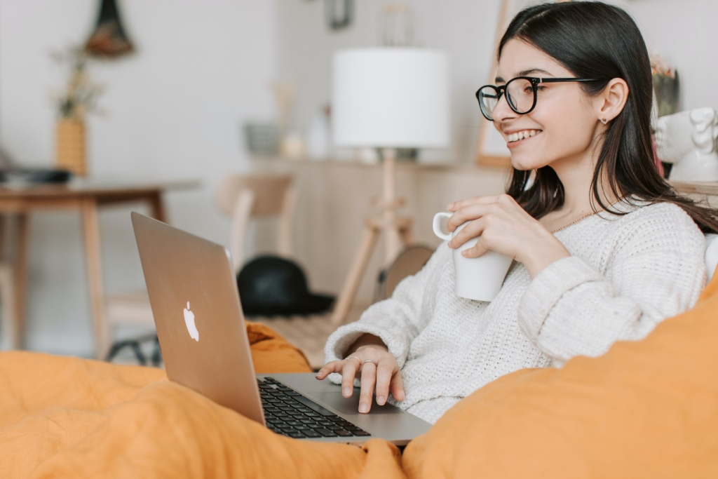 A woman using a laptop while having coffee