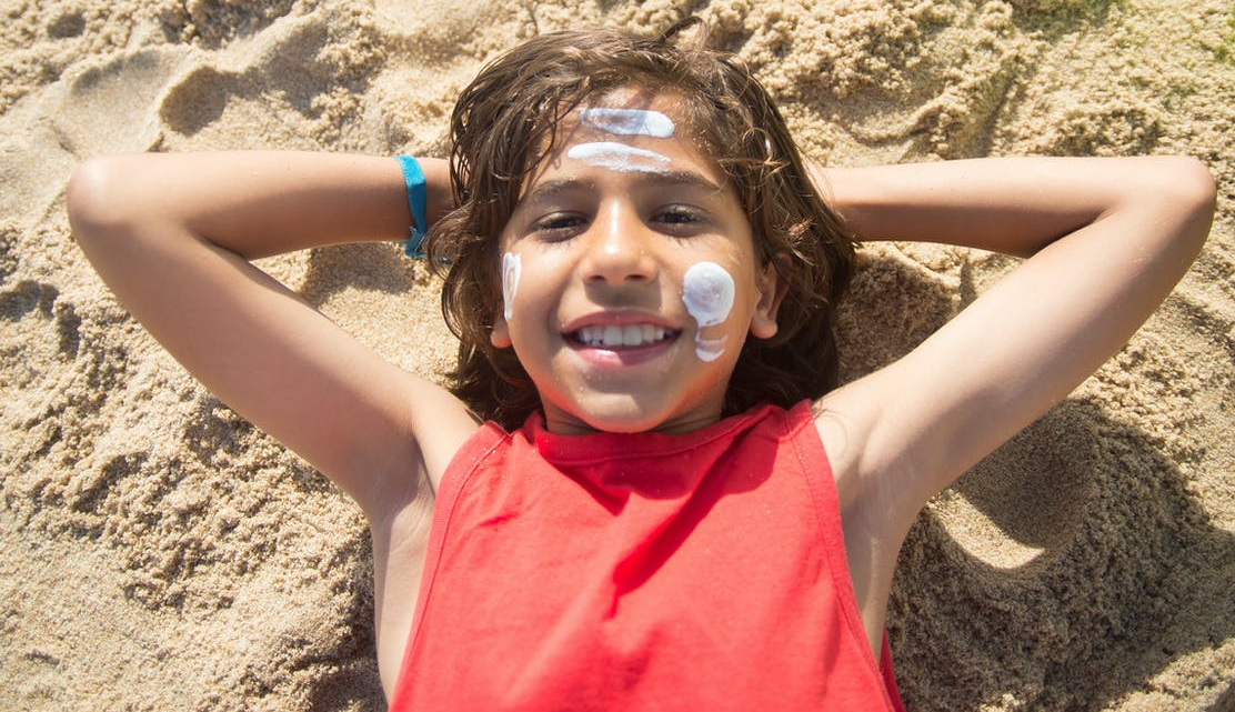  A boy wearing loose clothing lying on the beach