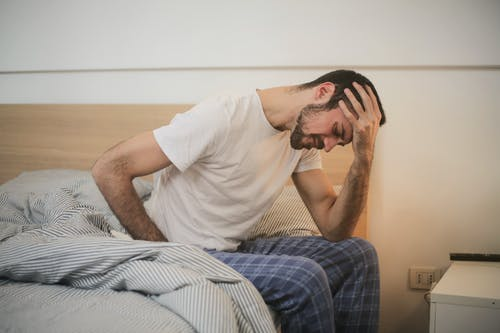 An upset man holding his head due to his sexual performance