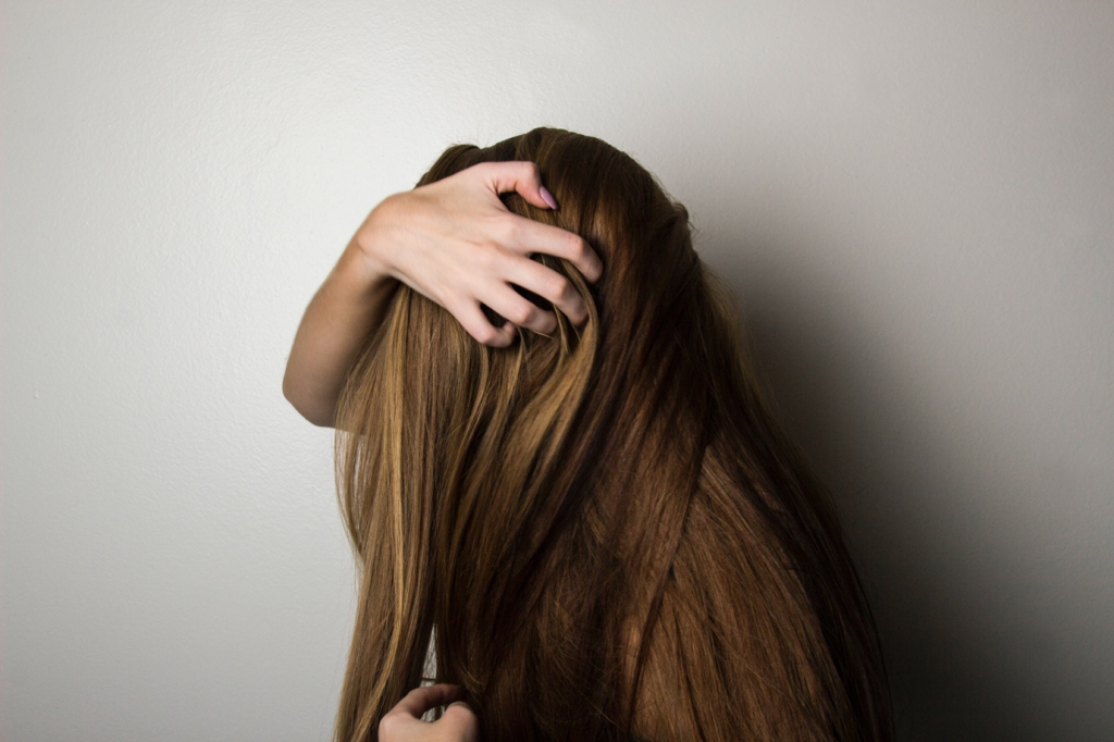 A person scratching their scalp due to itching